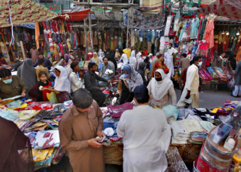 People buy garments after the government relaxed the weeks-long lockdown that was enforced to curb the spread of the coronavirus, at a market in Rawalpindi, Pakistan, Wednesday, May 13, 2020. (AP Photo/Anjum Naveed)