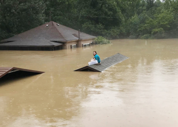 Photo of Chloe Adams sitting on the roof of a wait while she waited to be rescued.