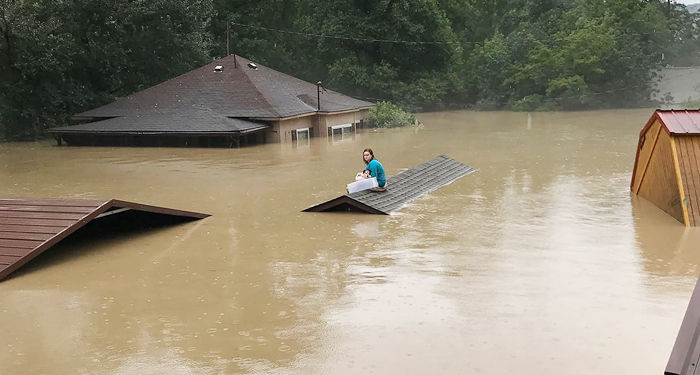 Photo of Chloe Adams sitting on the roof of a wait while she waited to be rescued.