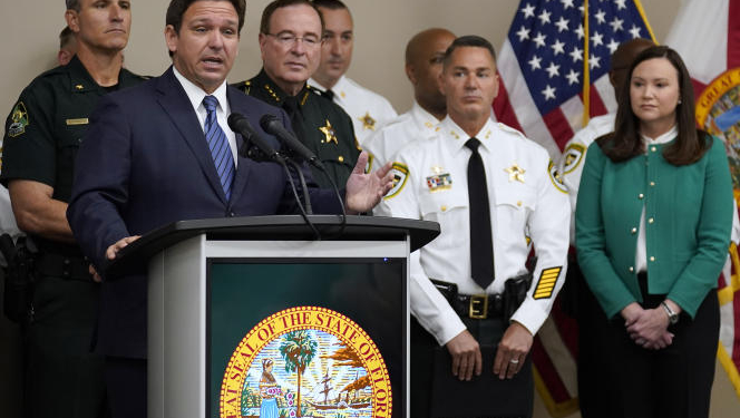 Florida Gov. Ron DeSantis, surrounded by members of law enforcement, gestures as he speaks during a news conference Thursday, Aug. 4, 2022, in Tampa, Fla. DeSantis announced that he was suspending State Attorney Andrew Warren, of the 13th Judicial Circuit, due to "neglect of duty." Looking on at right is Florida Attorney General Ashley Moody. (AP Photo/Chris O'Meara)