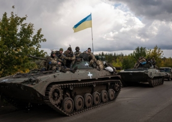 Ukrainian soldiers in armored vehicles in Izium on Saturday, Sept. 24, 2022. Ukraine’s president has urged citizens to resist the Russians in occupied territories, where voting is underway in what Western officials have called “sham” referendums on joining Russia. (Nicole Tung/The New York Times)