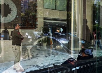 A police officer (L) stands near the reception desk of the office building where Indian tax authorities raided BBC's office in New Delhi on February 14, 2023. - The BBC said it was "fully cooperating" with Indian tax authorities raiding its New Delhi and Mumbai offices on February 14, weeks after it aired a documentary critical of Prime Minister Narendra Modi. (Photo by Uzair RIZVI / AFP)