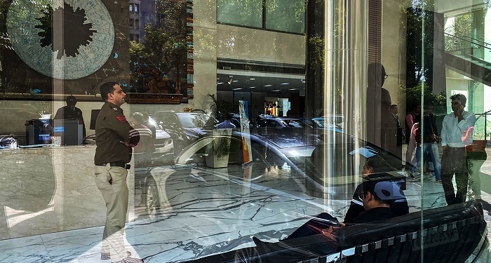 A police officer (L) stands near the reception desk of the office building where Indian tax authorities raided BBC's office in New Delhi on February 14, 2023. - The BBC said it was "fully cooperating" with Indian tax authorities raiding its New Delhi and Mumbai offices on February 14, weeks after it aired a documentary critical of Prime Minister Narendra Modi. (Photo by Uzair RIZVI / AFP)