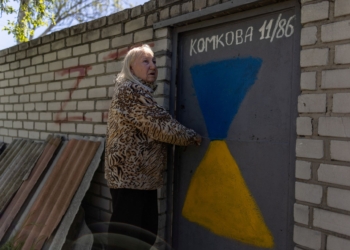 Valentyna Haras, 74, stands outside her home next to graffiti with the letter Z, painted by neighbours, which has become a symbol of the Russian military, as Russia's attack on Ukraine continues, in Kherson, Ukraine, May 3, 2023. REUTERS