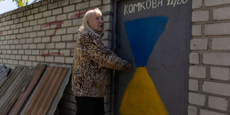 Valentyna Haras, 74, stands outside her home next to graffiti with the letter Z, painted by neighbours, which has become a symbol of the Russian military, as Russia's attack on Ukraine continues, in Kherson, Ukraine, May 3, 2023. REUTERS