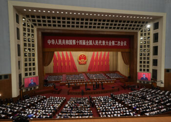 FILE - Chinese Premier Li Qiang is seen on screens as he speaks during the opening session of the National People's Congress (NPC) at the Great Hall of the People in Beijing, on March 5, 2024. (AP Photo/Ng Han Guan, File)